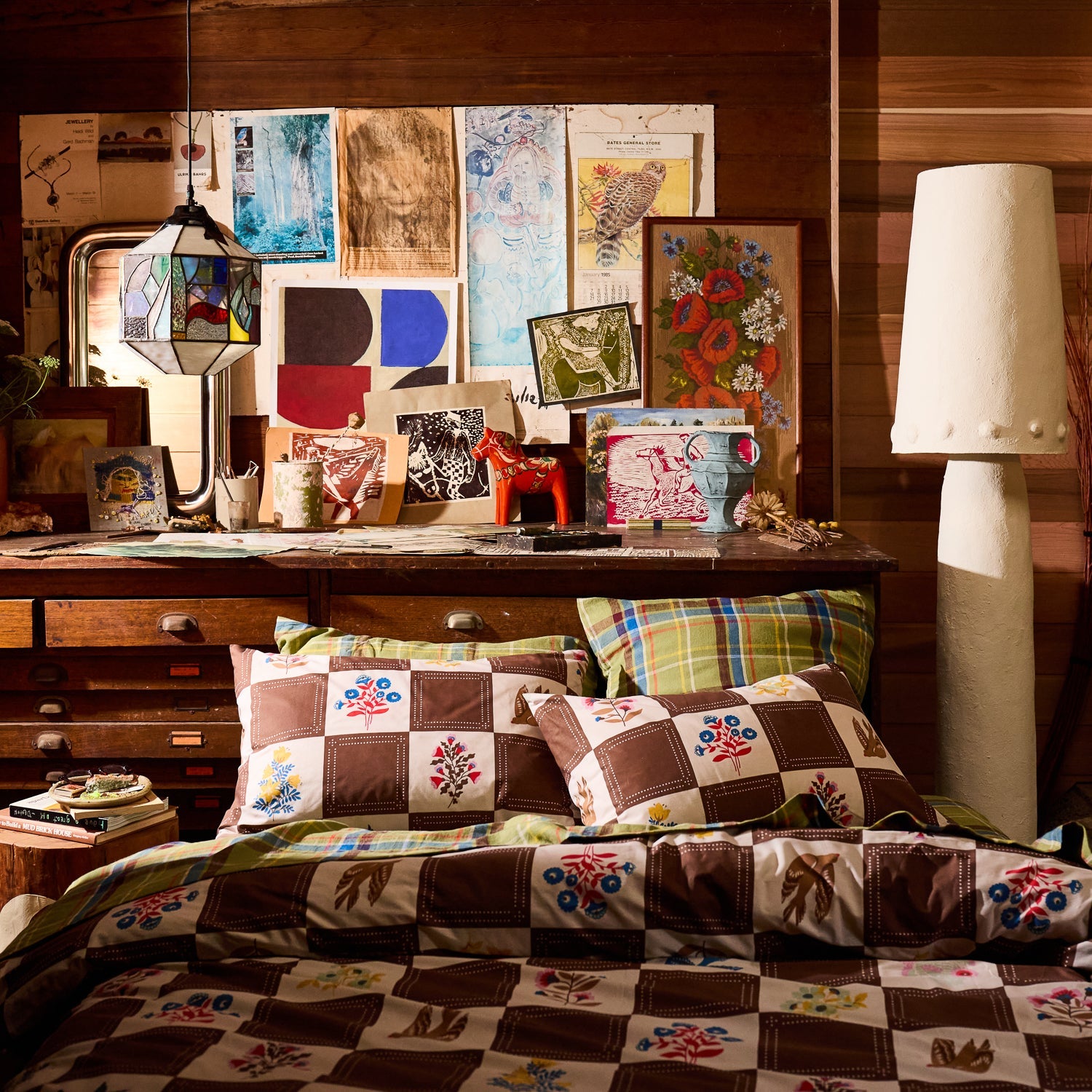 Two brown checkerboard folk floral print cotton pillowcases on a bed in an eclectic styled bedroom