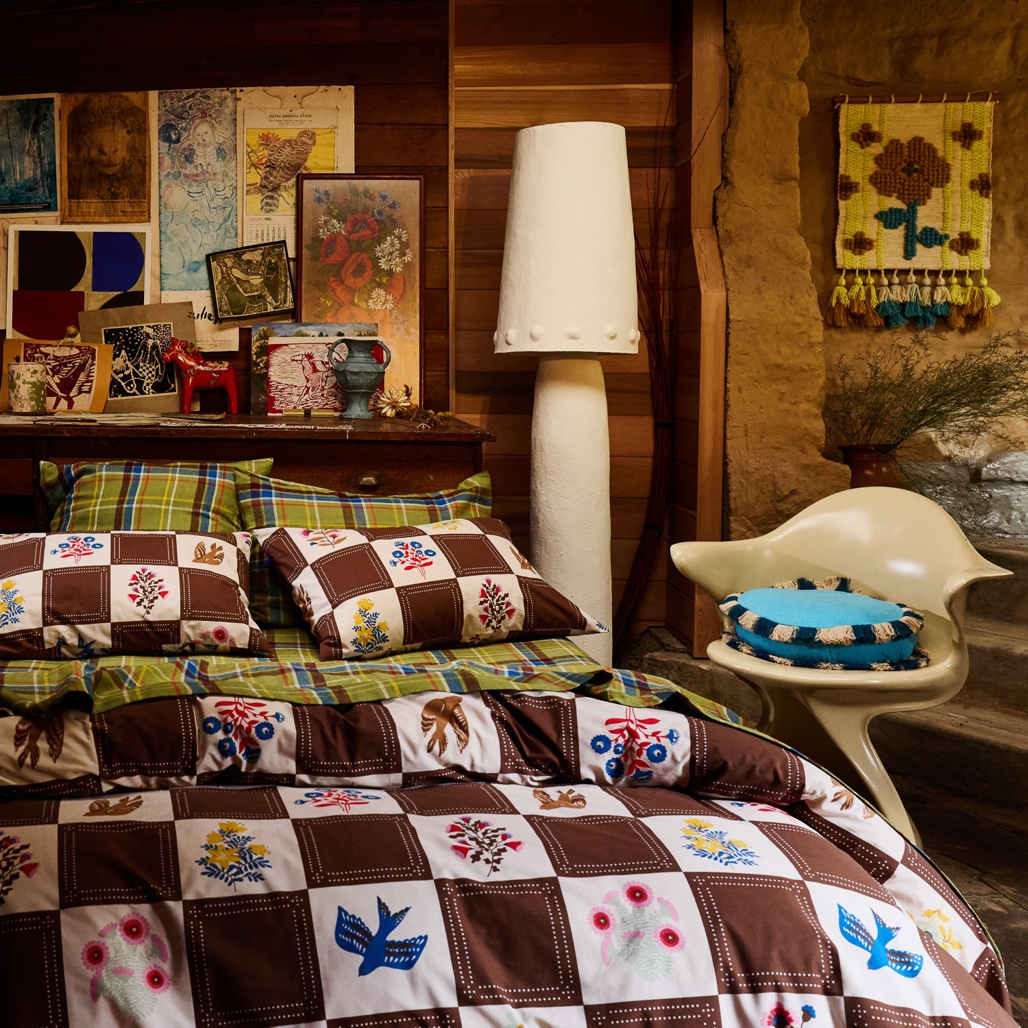 Cotton quilt cover in brown and cream checkerboard with colourful floral and bird motifs on a styled bed