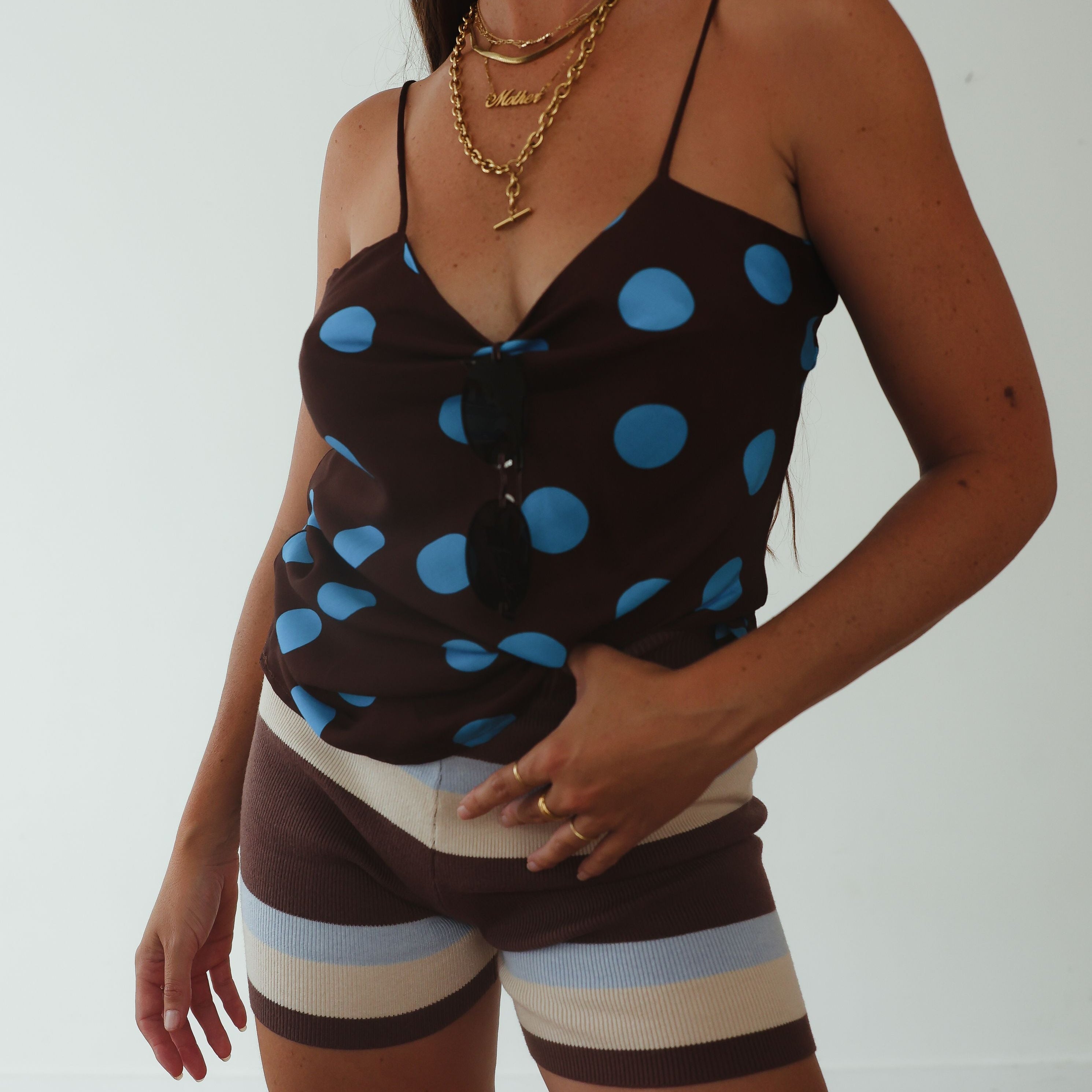 Studio portrait view of womens striped knit shorts in brown, cream and blue horizontal pattern