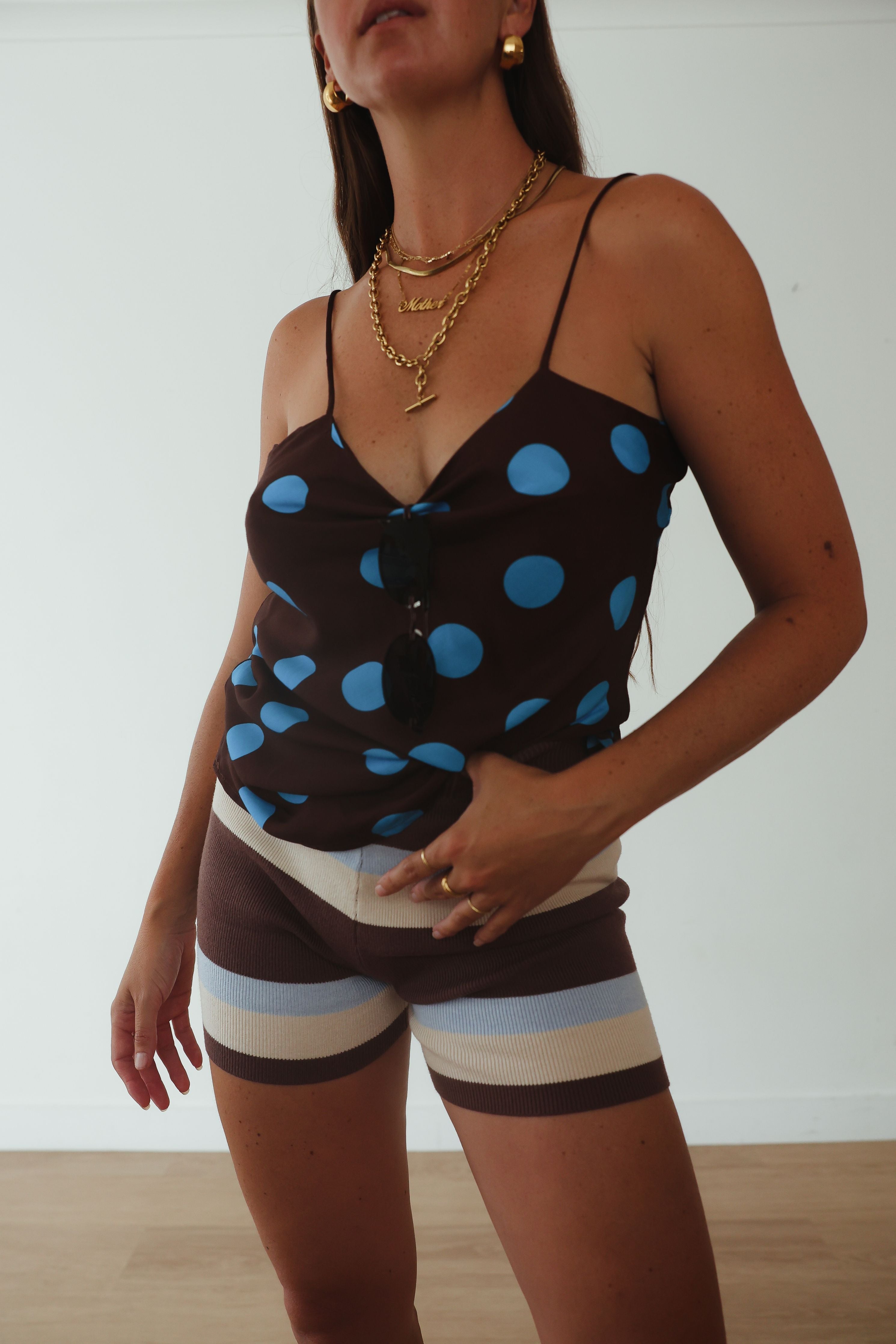 Studio portrait view of womens striped knit shorts in brown, cream and blue horizontal pattern