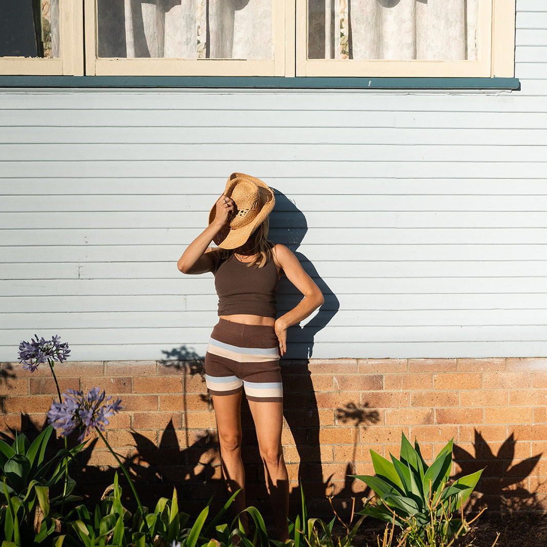 Studio styling shot featuring brown, cream and blue striped knit shorts with polka dot cami top