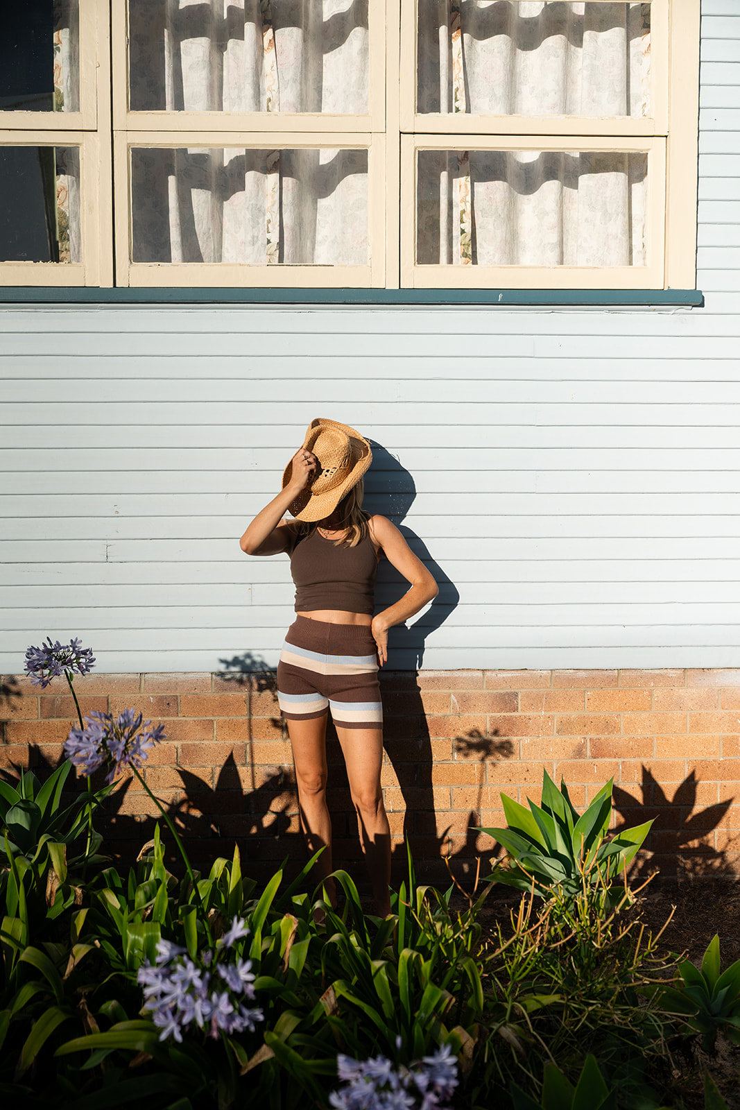 Studio styling shot featuring brown, cream and blue striped knit shorts with polka dot cami top