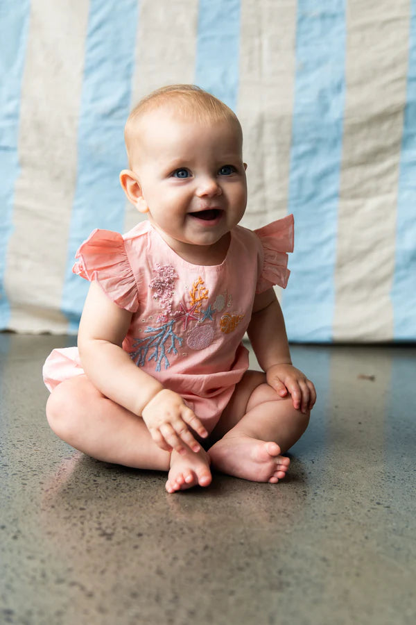 baby wearing pink baby onesie with coral embroidery - great baby shower gift idea