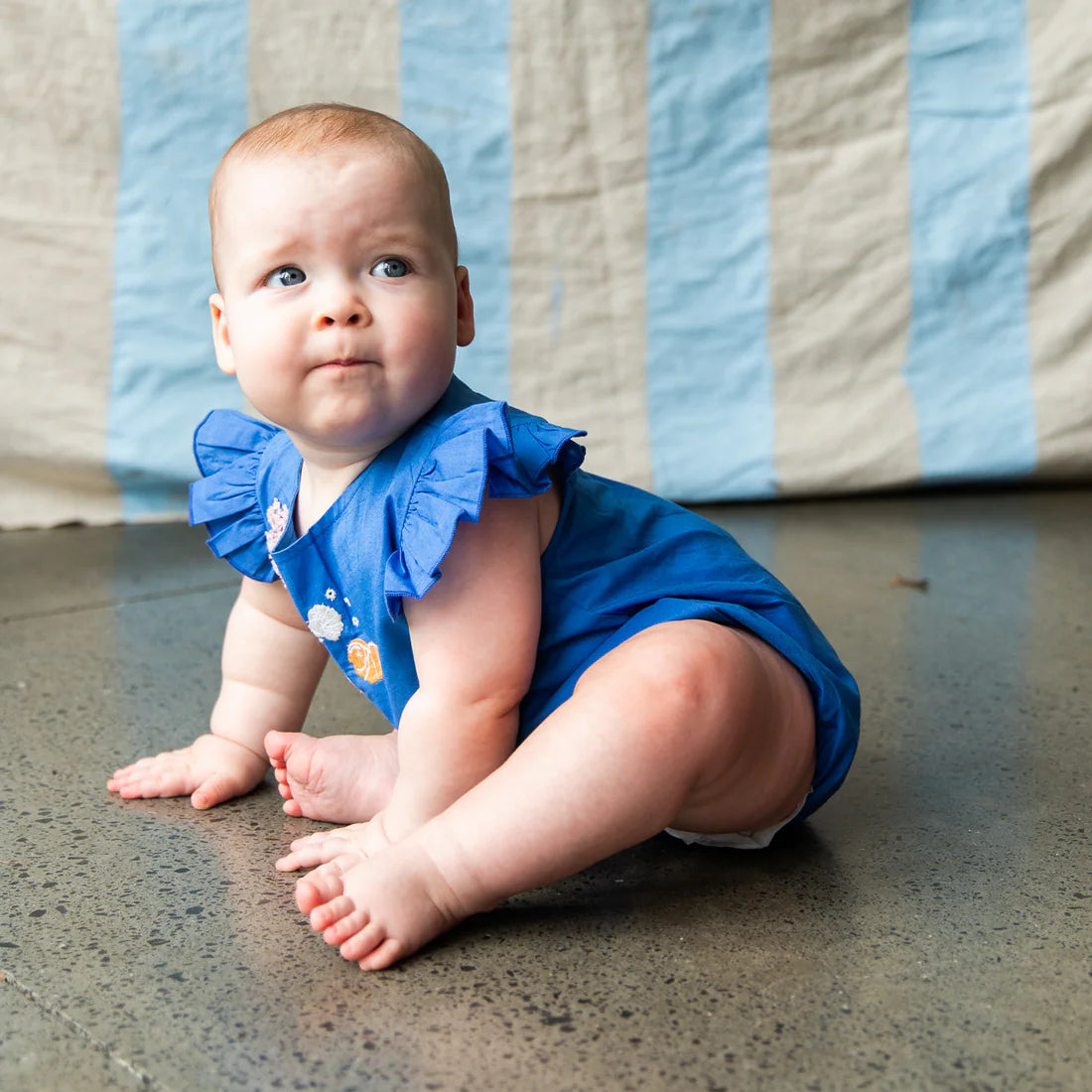 baby wearing bright blue Pearson an Pearson onesie