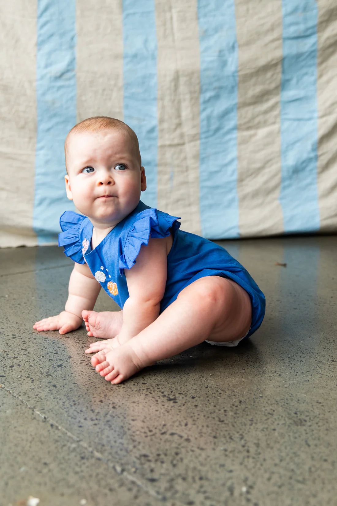 baby wearing bright blue Pearson an Pearson onesie