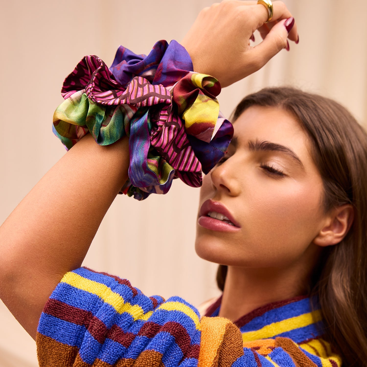 Colorful silk scrunchie set worn on wrist showing vibrant purple yellow green multicolor print patterns