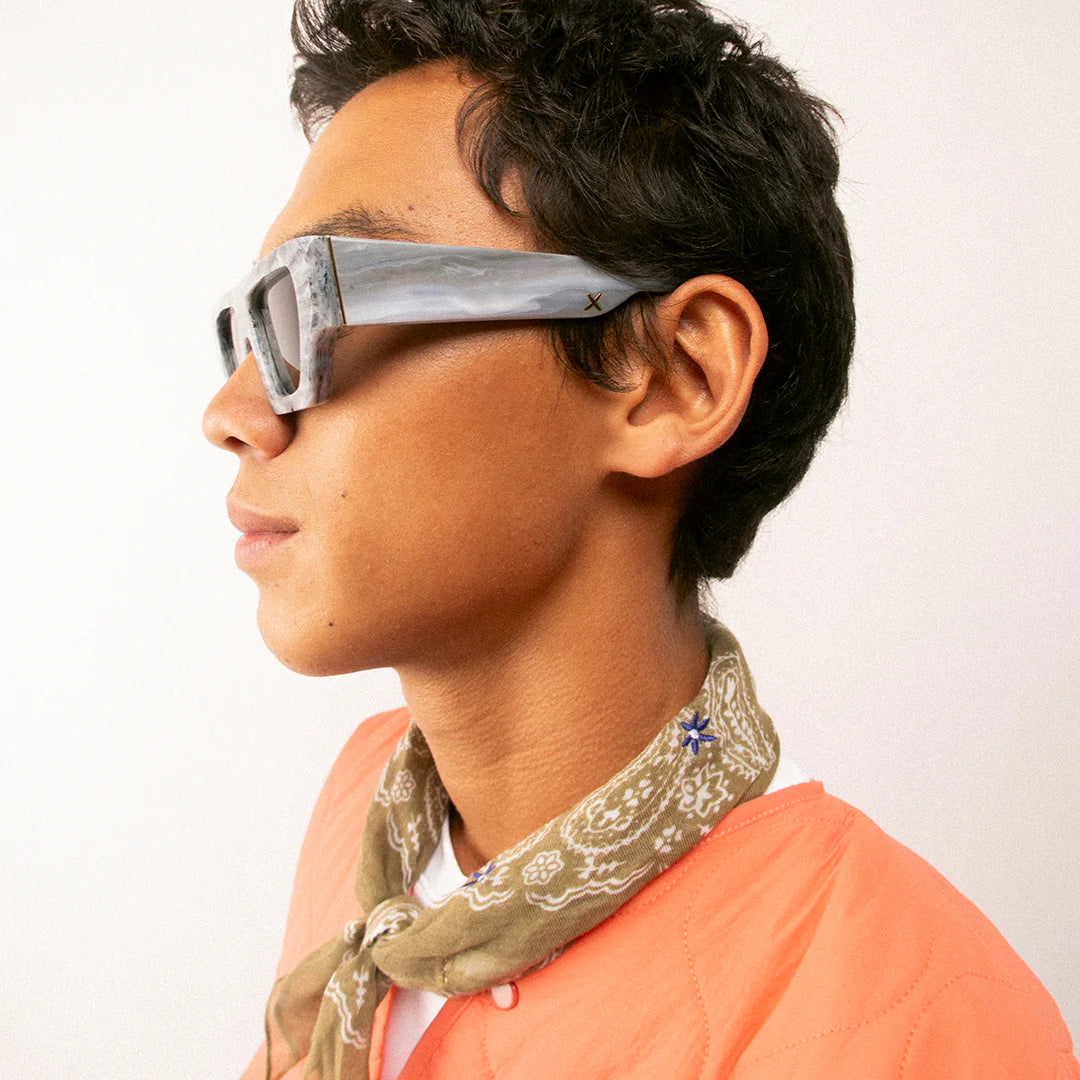 Person wearing futuristic sunglasses by Oscar Frank with a plain background