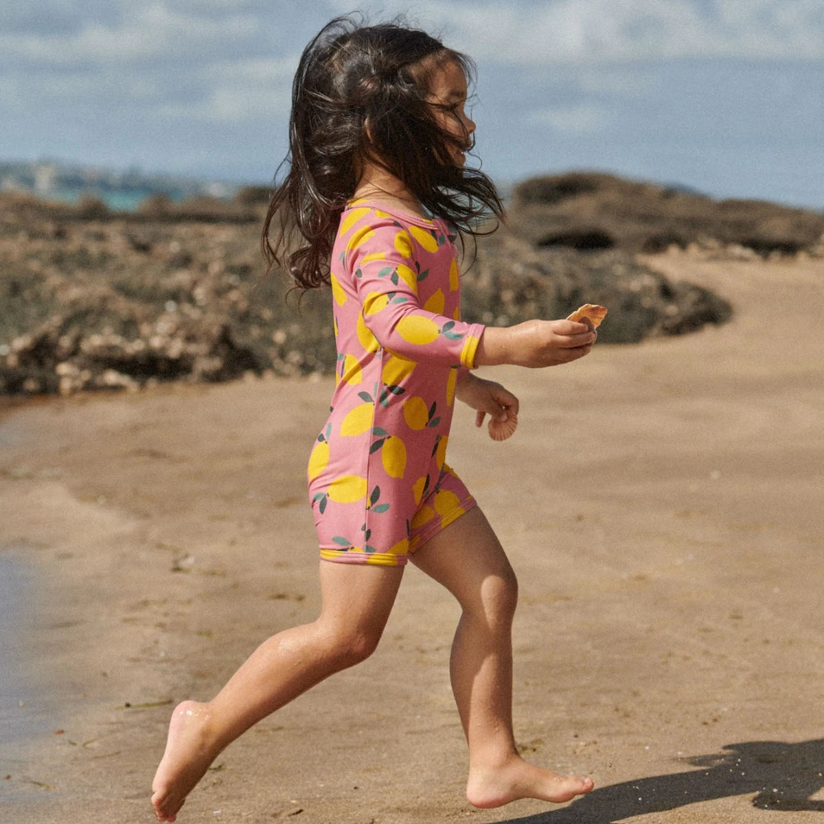 girl wearing pink swimsuit with yellow lemon print - by Nature Baby