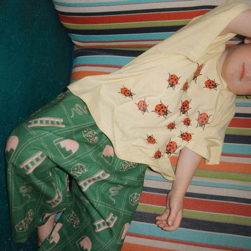 Child wearing the green snakes and ladder pants by Sauce Mini