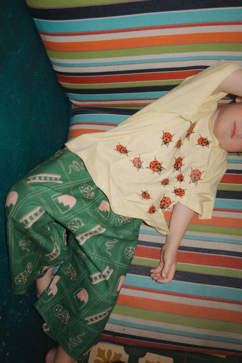 Child wearing the green snakes and ladder pants by Sauce Mini