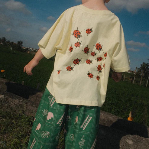 back of Child wearing the green snakes and ladder pants by Sauce Mini