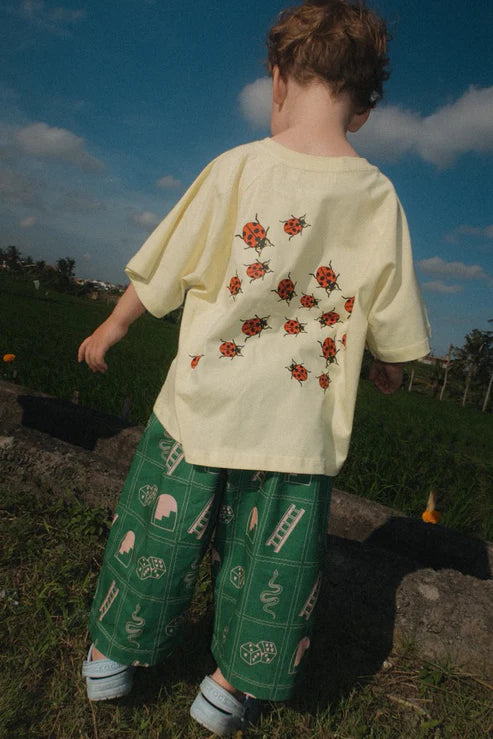 back of Child wearing the green snakes and ladder pants by Sauce Mini