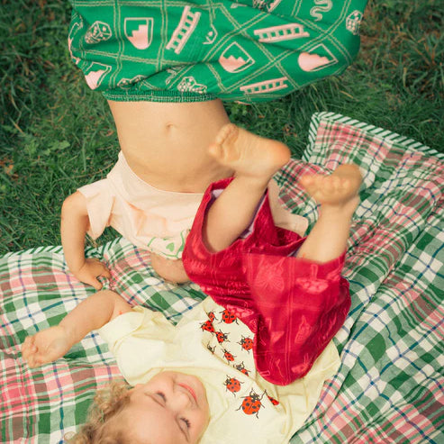 Child wearing the green snakes and ladder pants by Sauce Mini