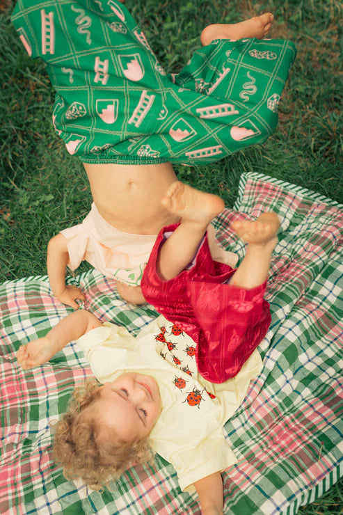 Child wearing the green snakes and ladder pants by Sauce Mini