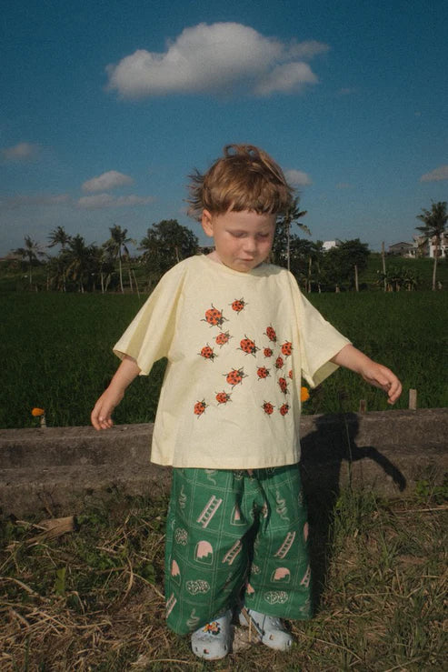 Child wearing the green snakes and ladder pants by Sauce Mini