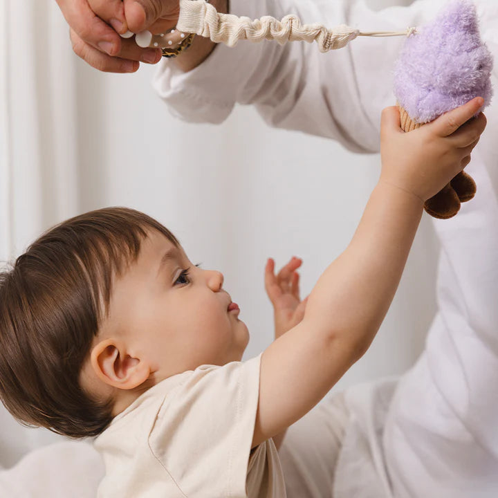 Boy playing with stroller toy by living textiles