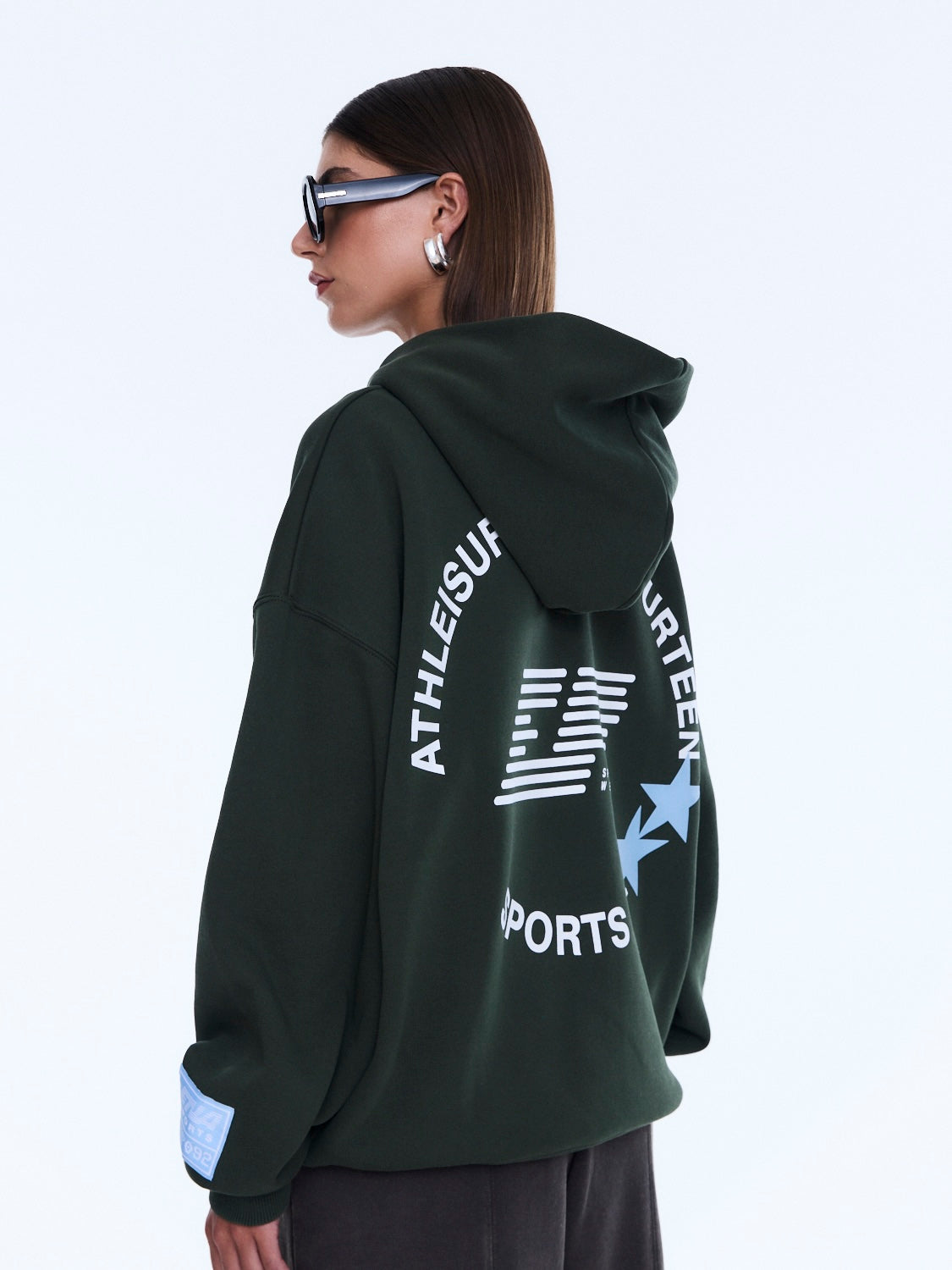 Three-quarter back view of Aries Hoodie displaying text and star graphic