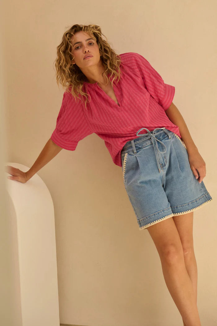 Model wearing Abigail Shorts – 70s Blue by Kireina - blue denim shorts with lace stitch detailing around the hem and pockets