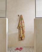 Abundance Marigold Printed Terry Bath Robe by Kip & Co hanging in bathroom