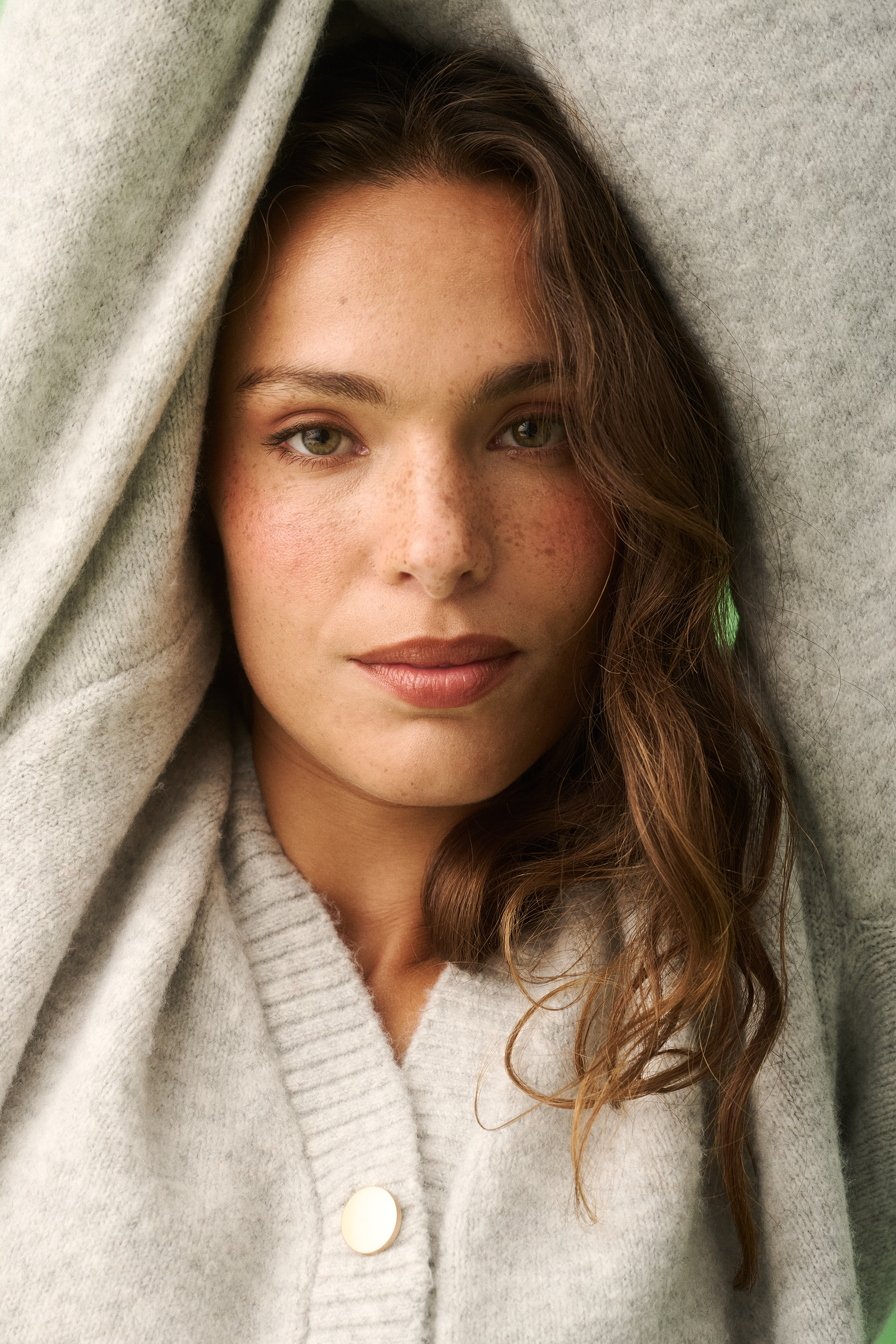 Close-up of grey marle knit cardigan showing ribbed collar and cream button detail