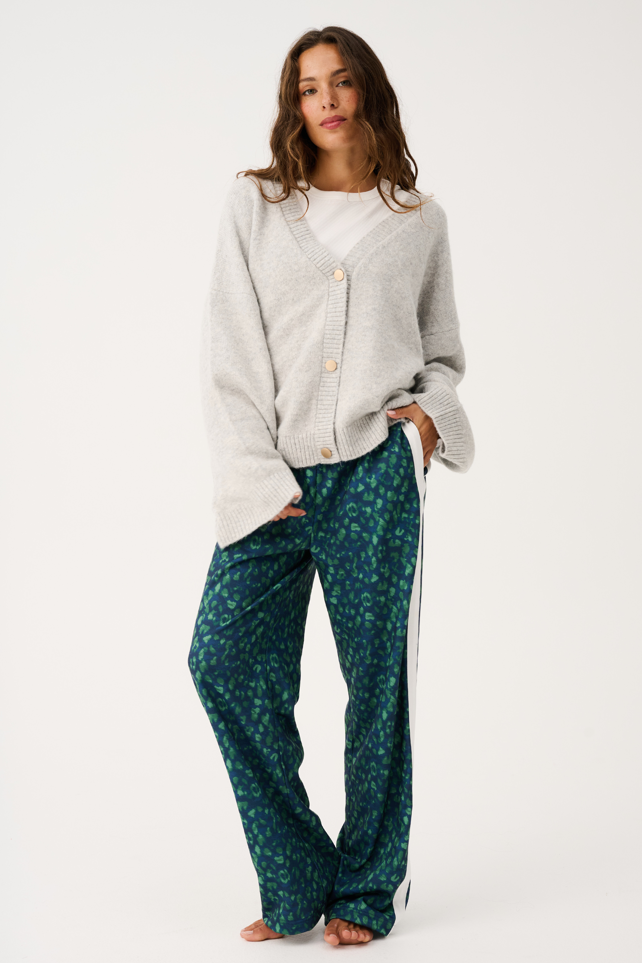 Full body view showing oversized fit of grey marle knit cardigan with long sleeves