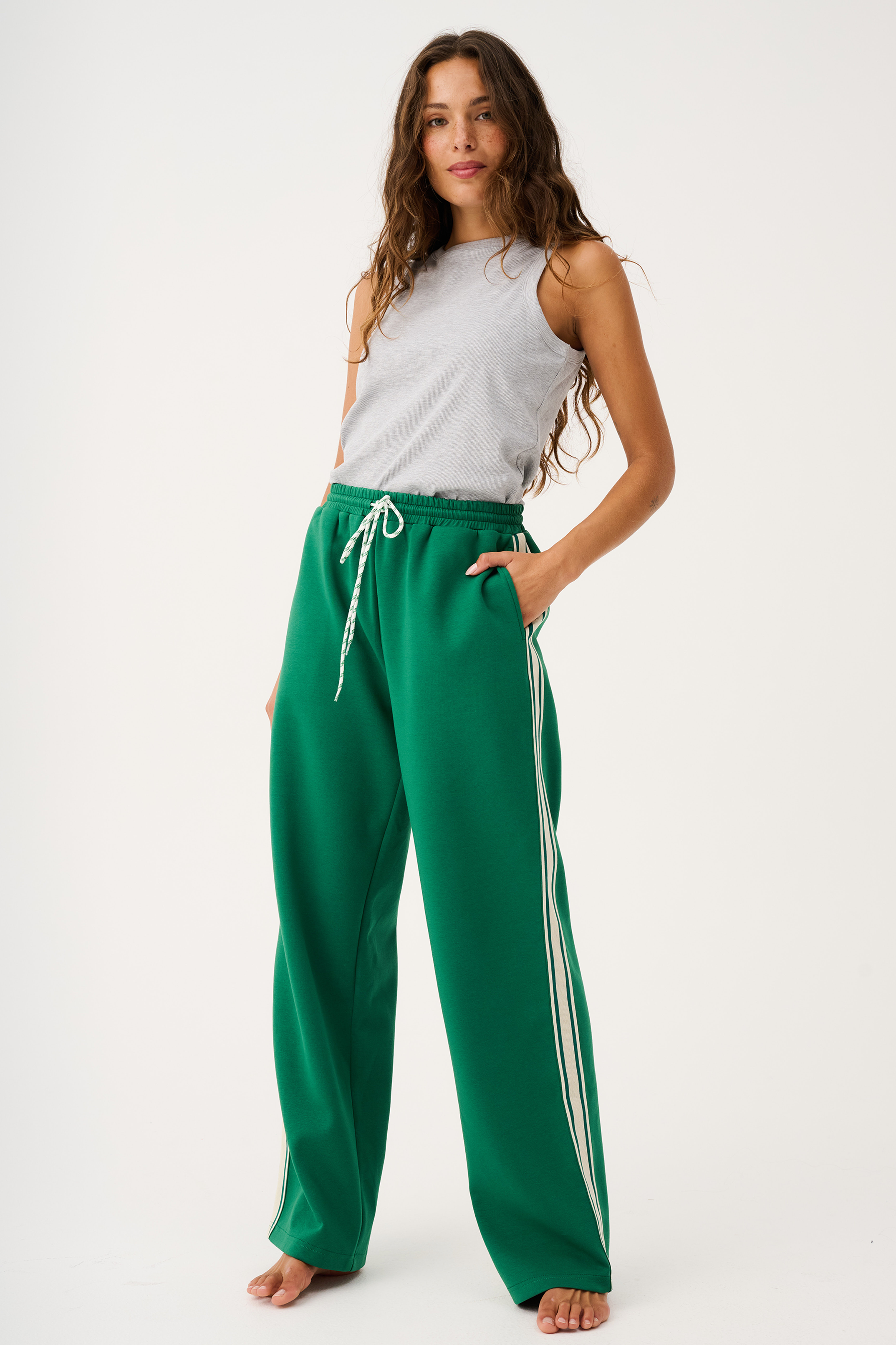 Front view of green Adeline Pants with white side stripes and drawstring waist in tide colorway
