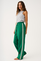 Three-quarter view of Adeline Pants showing relaxed wide-leg fit and athletic stripe trim