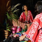 Red cotton robe with palm leaf print and plaid trim details worn in bathroom setting