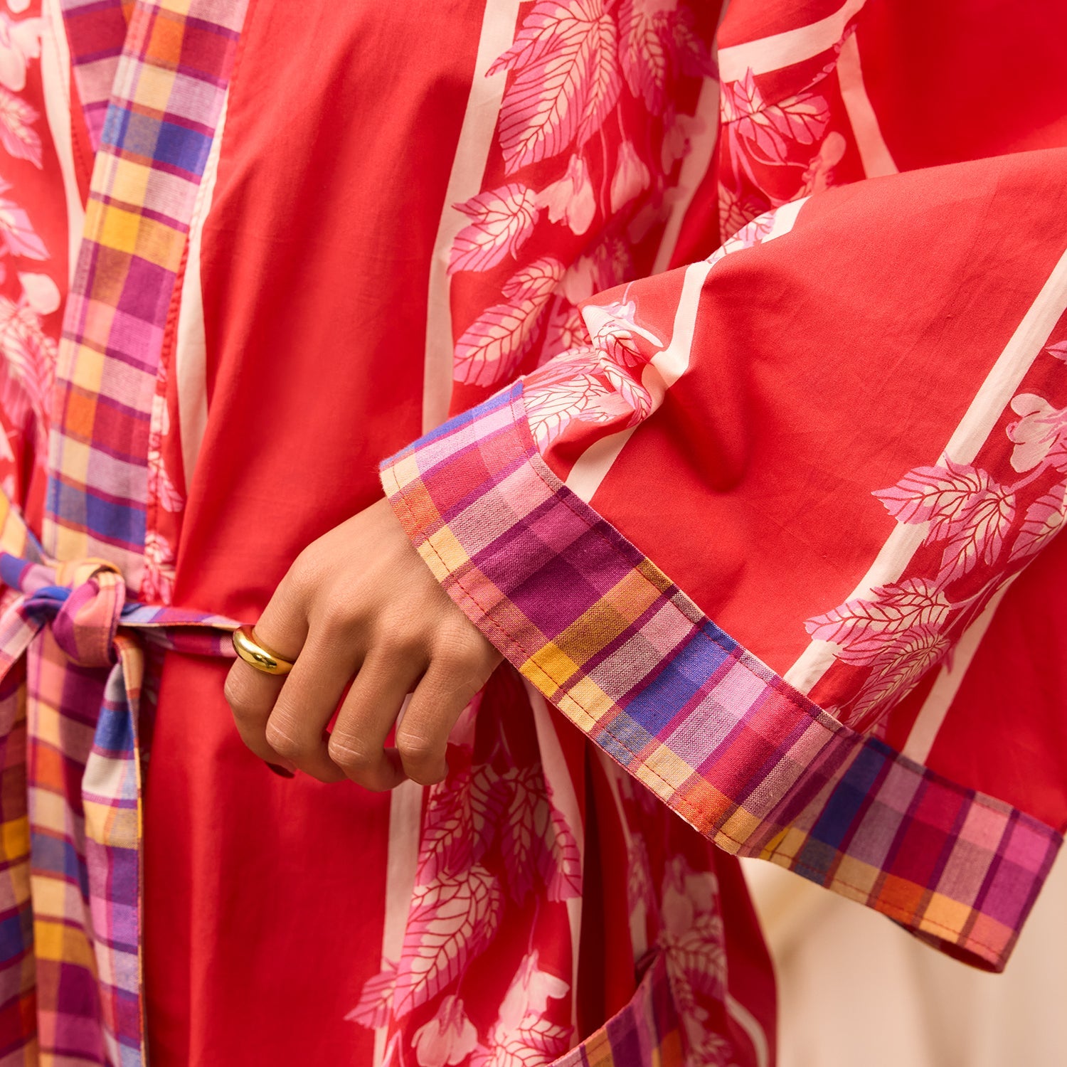 Close-up detail of cotton robe sleeve with colorful plaid cuff trim