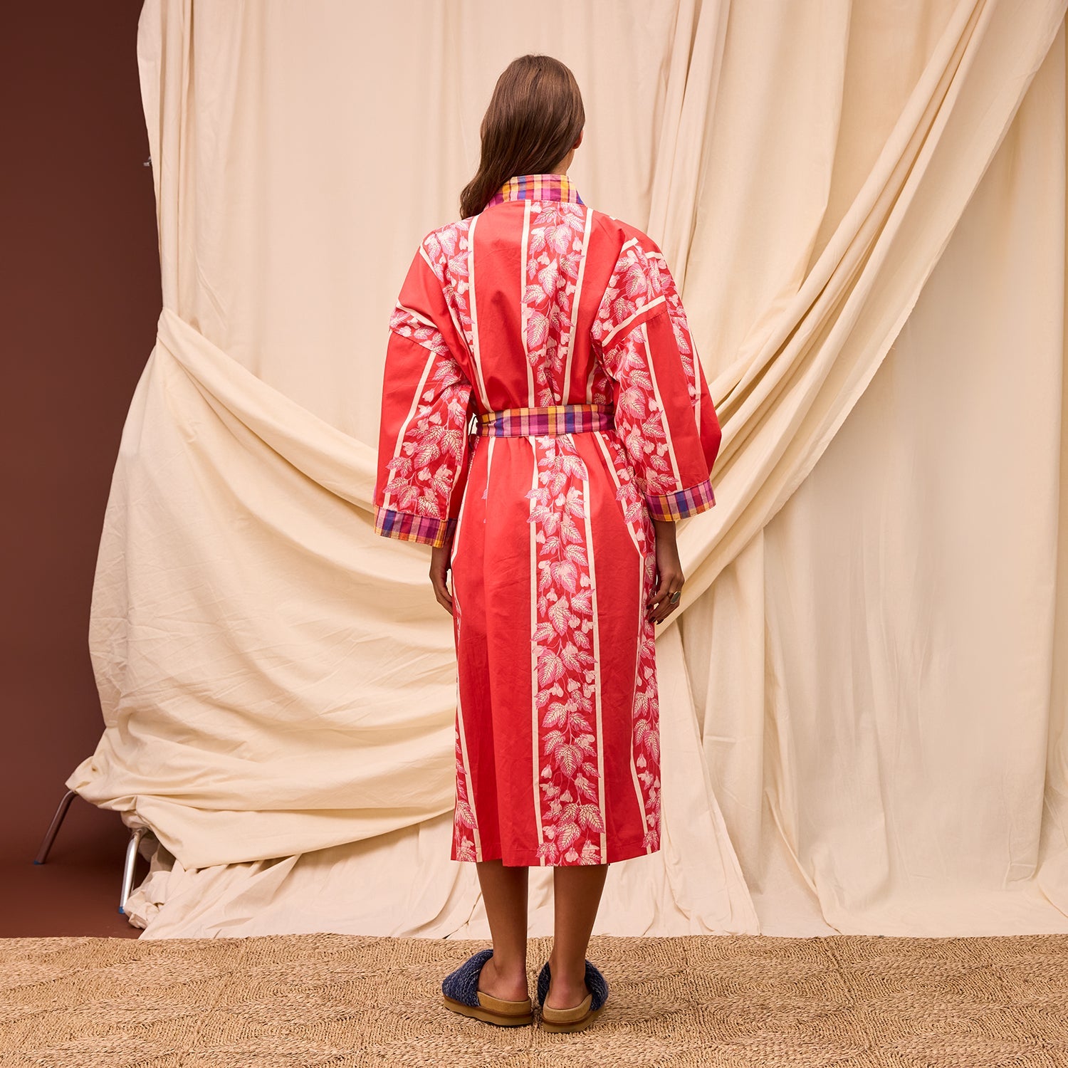Back view of red cotton robe displaying full-length kimono style and plaid belt