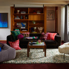 Wide angle view of Agata Velvet Cushion in modern living room interior with built-in shelving