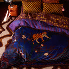 Andrea Velvet Bedcover by Sage & Clare styled on bed showing tiger print design and fringe trim details
