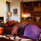 Sage & Clare Andrea Velvet Bedcover in modern bedroom setting with blue tiger pattern and striped reverse side
