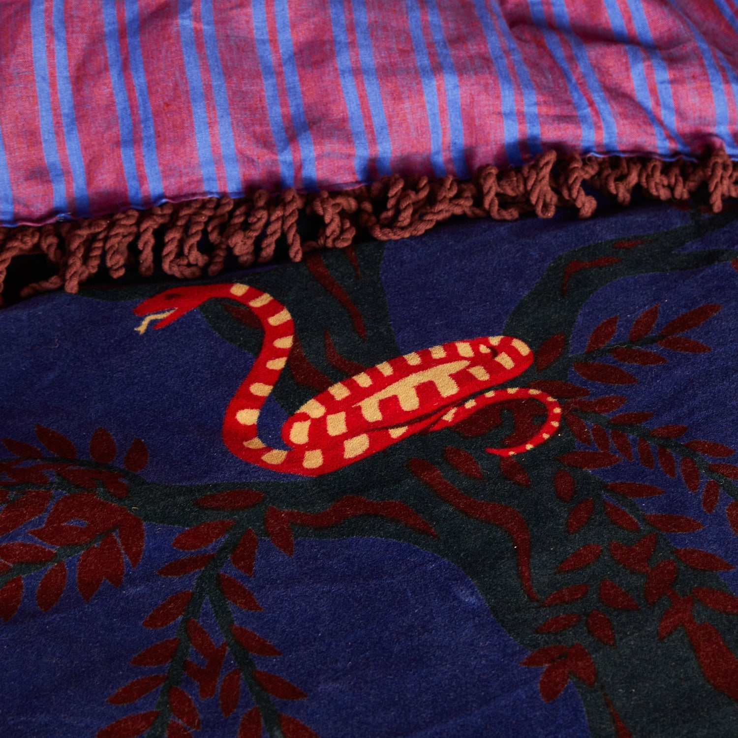 Close-up detail of orange tiger motif on navy blue velvet fabric of Andrea Bedcover by Sage & Clare