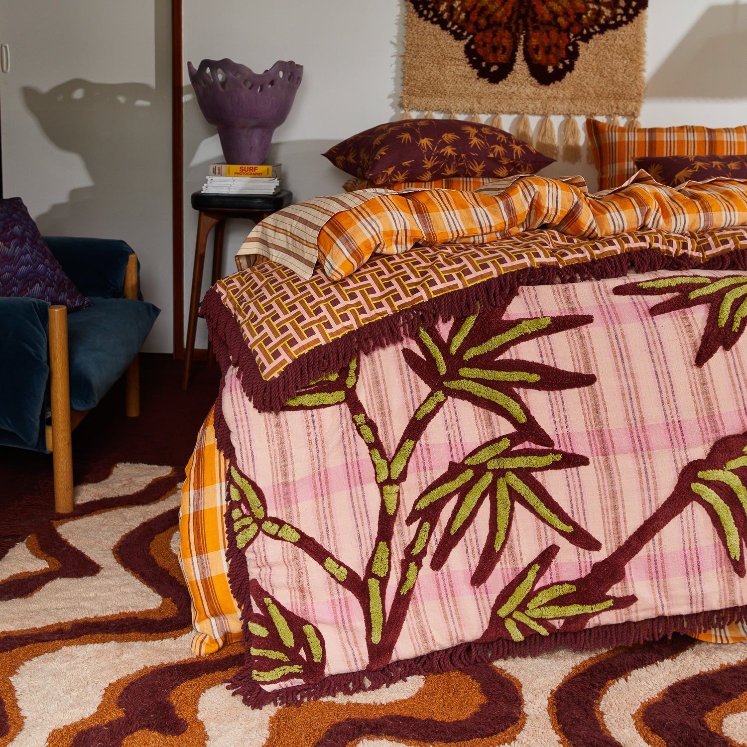 Close-up detail of Aneta Tufted Blanket showing geometric pattern border and burgundy tufted fringe trim