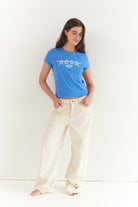 Full body shot of azure blue Star Baby Tee with white star design and short sleeves