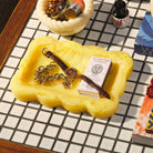 Aspen Gold marbled resin small tray holding a watch and matches, styled on a mosaic tile surface