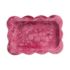 Crimson pink marbled resin small tray with scalloped wavy border, overhead view showing rectangular interior on white