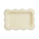 Pearl cream resin small tray with scalloped wavy border, overhead view showing shallow rectangular interior on white