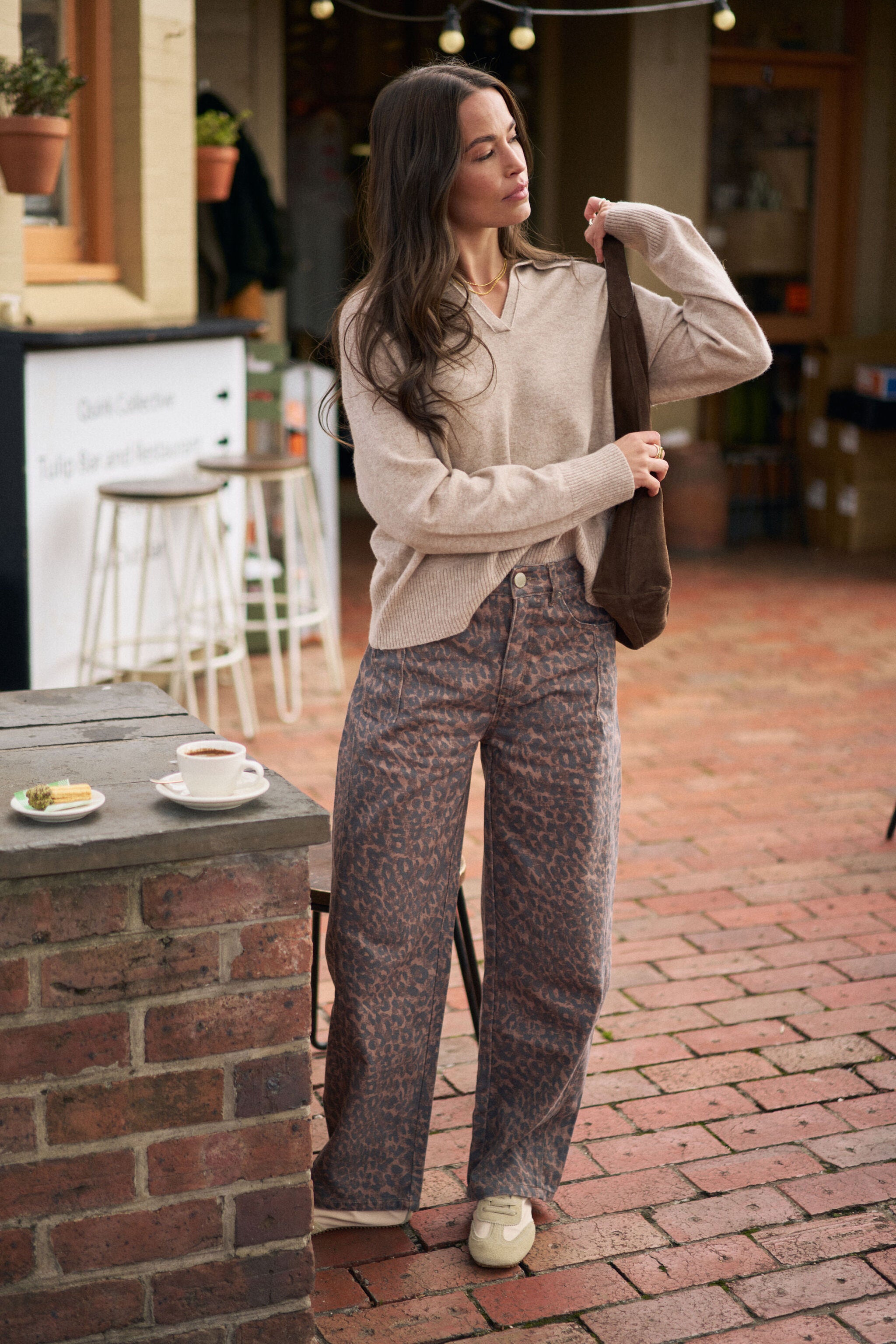 Full body shot of woman in oat marle knit pullover showing relaxed oversized fit