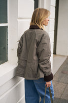Back angle view of moss green barn jacket with corduroy collar and relaxed silhouette