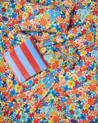 Flat lay of Blue Robin cushion on colorful floral pattern background