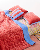 Blue Robin striped velvet cushion styled with matching bedding on bed