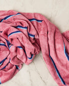 Bunched Blushing Stripe bamboo terry bath sheet on marble surface displaying soft drape and striped design
