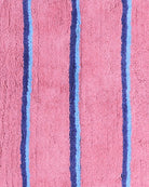 Detail view of Blushing Stripe Bath Mat texture showing pink base with blue striped pattern by Kip & Co