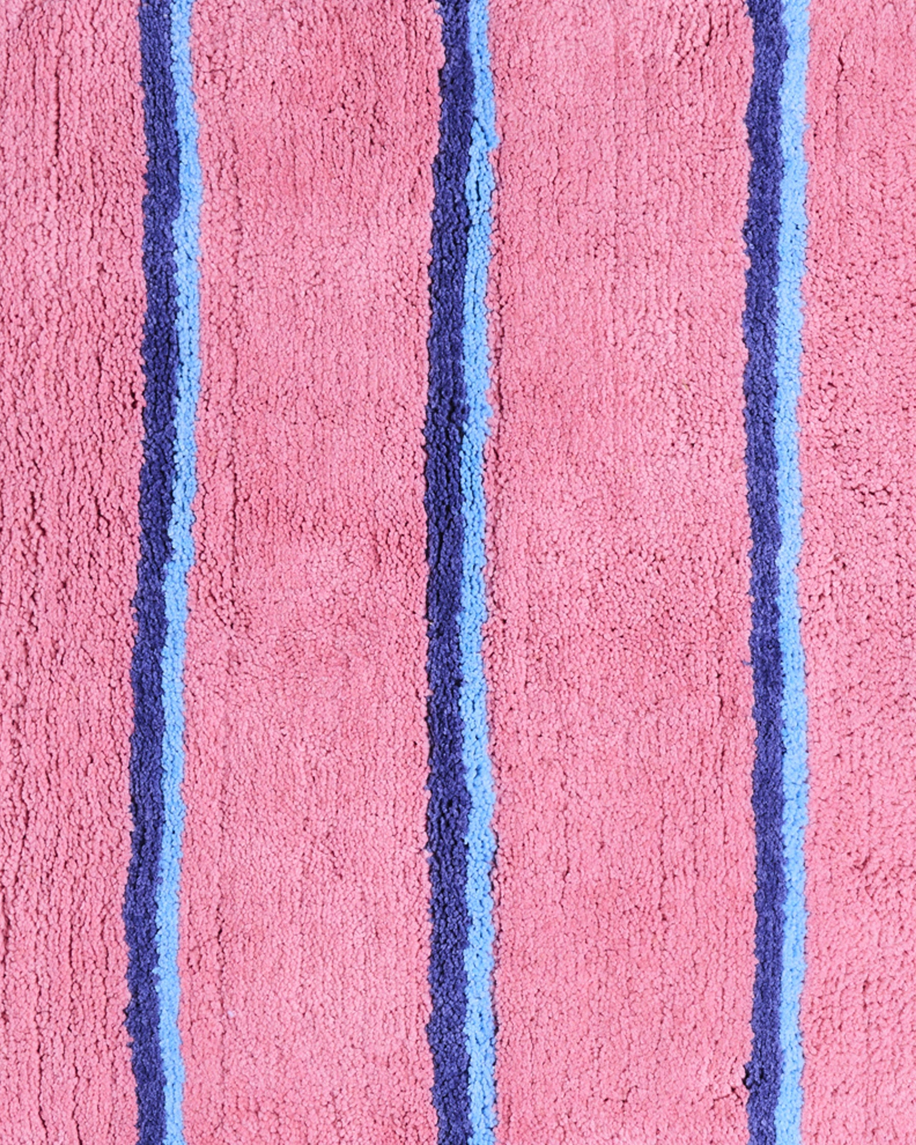Detail view of Blushing Stripe Bath Mat texture showing pink base with blue striped pattern by Kip & Co