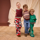 Close-up portrait of three children showcasing various knit styles including checkered Bodhi pants