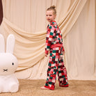 Side view of Bodhi Kids knit sweater and pants showing full colorful checkered design and red trim details