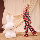 Child in Bodhi Kids knit pajamas showing complete colorful checkered sweater and matching pants set
