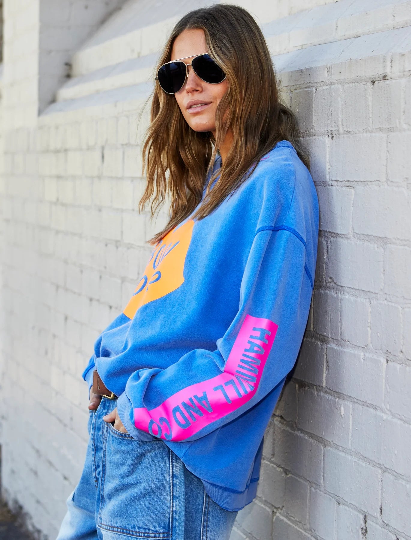 Bonjour washed blue sweater by Hammill & Co with orange bonjour graphic on front and pink Hammill & Co logo down the sleeve